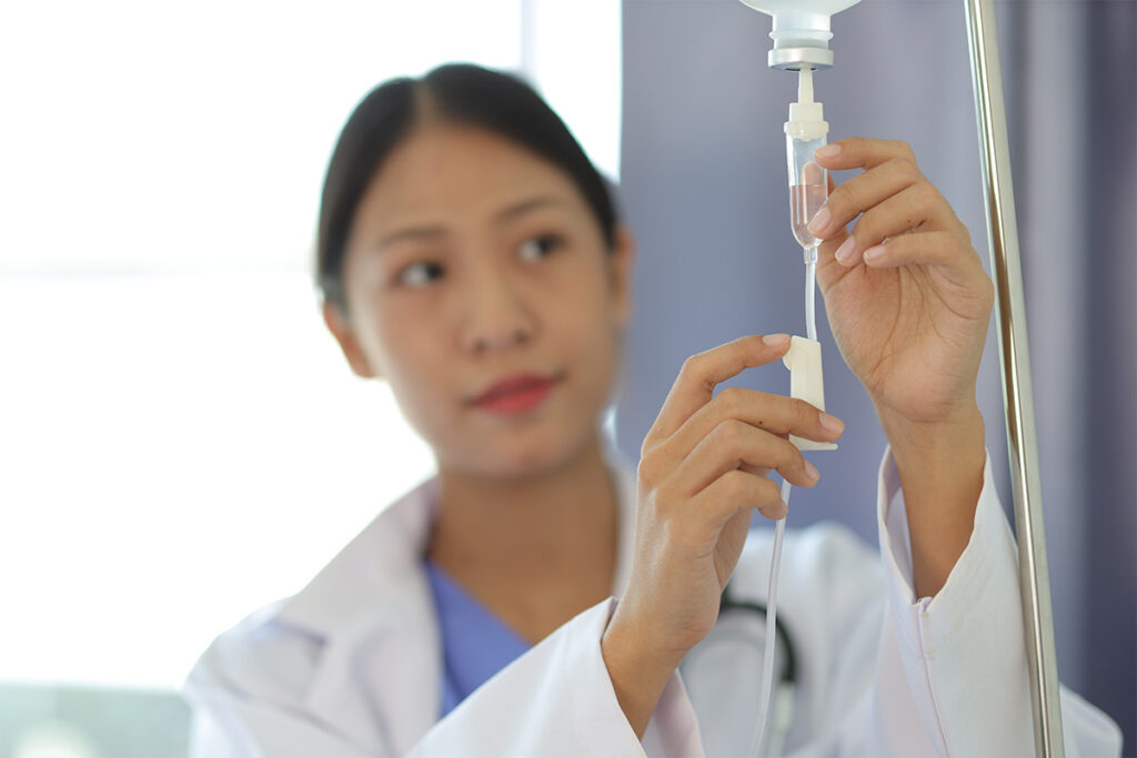 a nurse sets up an iv drip for a patient