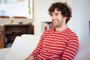 a man smiles on the couch