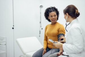 a doctor takes blood pressure for a patient