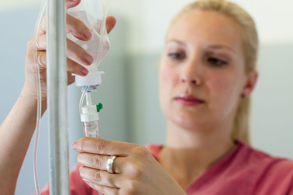 a nurse adjusts the dosage of an I V drip