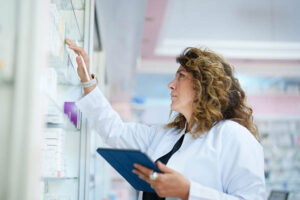 Pharmacist inventorying shelf