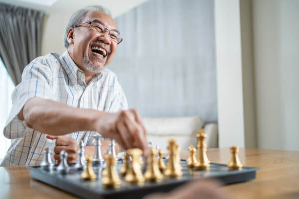 Happy older man playing chess