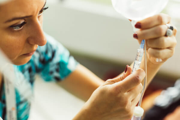 Woman nurse adjusting an IV drop